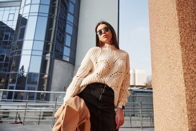 Hermoso reflejo en las ventanas. Hermosa joven en ropa de abrigo tiene caminar en la ciudad en su tiempo de los fines de semana