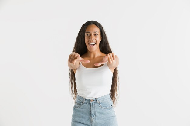 Hermoso retrato femenino aislado. Joven mujer afroamericana emocional con cabello largo. Expresión facial, concepto de emociones humanas. Señalando y eligiendo,