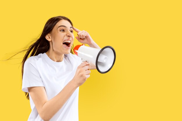 Hermoso retrato femenino de medio cuerpo aislado en espacio amarillo. Mujer sonriente joven. Expresión facial, verano, fin de semana, concepto de resort.