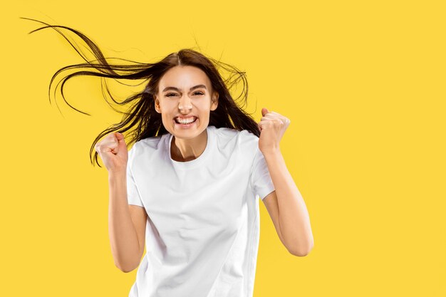 Hermoso retrato femenino de medio cuerpo aislado en estudio amarillo