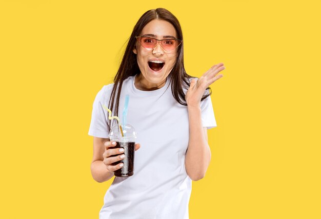 Hermoso retrato femenino de medio cuerpo aislado en estudio amarillo