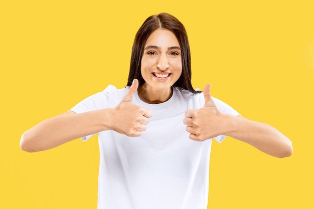 Hermoso retrato femenino de medio cuerpo aislado en estudio amarillo