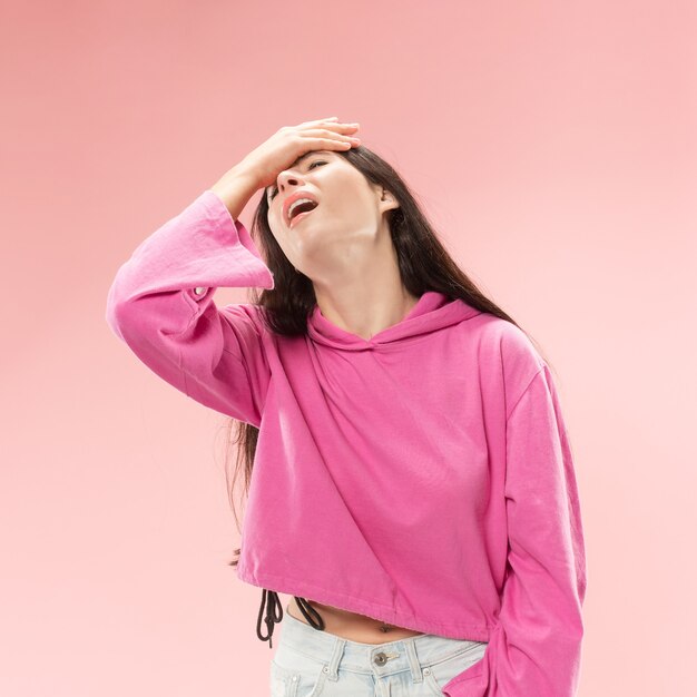 Hermoso retrato femenino de medio cuerpo aislado en el fondo de color rosa de moda del estudio.