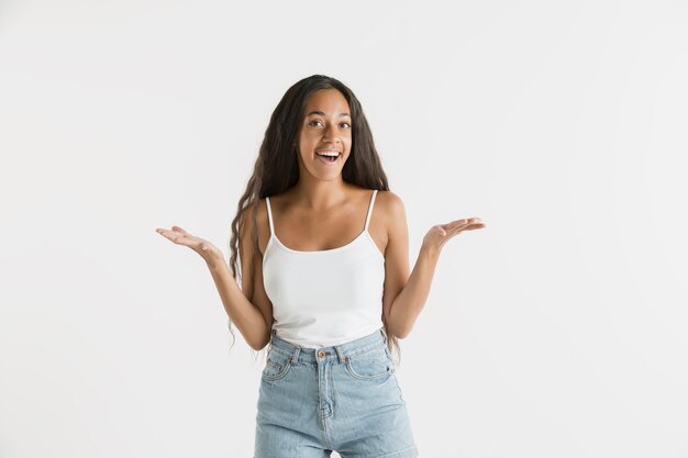 Hermoso retrato femenino de medio cuerpo aislado en la pared blanca. Joven mujer afroamericana emocional con cabello largo. Expresión facial, concepto de emociones humanas. Asombrado, emocionado.