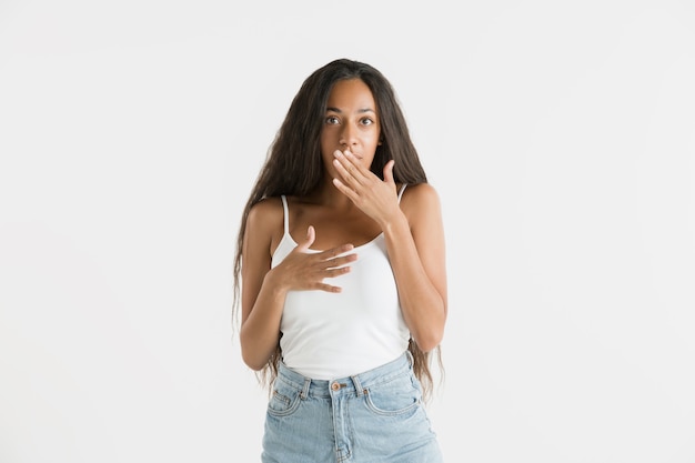 Foto gratuita hermoso retrato femenino de medio cuerpo aislado sobre fondo blanco de estudio. joven mujer afroamericana emocional con cabello largo. expresión facial, concepto de emociones humanas. asombrado, emocionado.