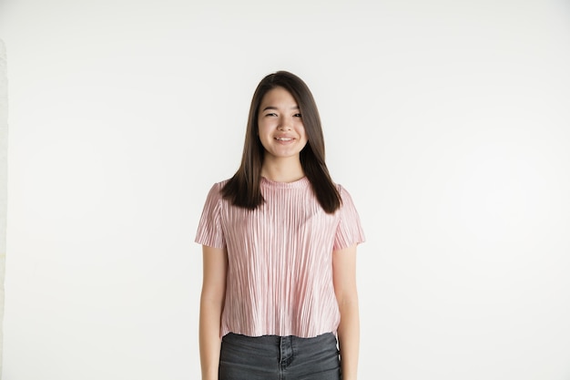 Foto gratuita hermoso retrato femenino de medio cuerpo aislado sobre fondo blanco de estudio. mujer joven emocional en ropa casual. las emociones humanas, el concepto de expresión facial. sonriendo, parece confiado.