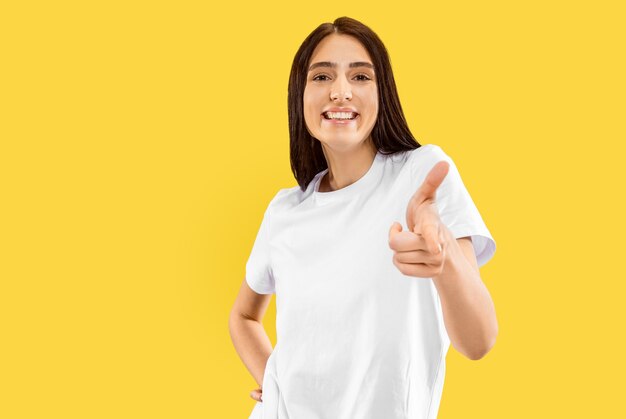 Hermoso retrato femenino de medio cuerpo en estudio amarillo