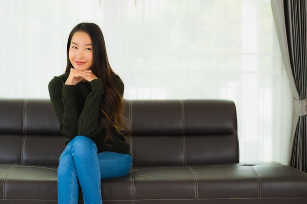 Hermoso retrato joven mujer asiática sentarse relajarse en el sofá