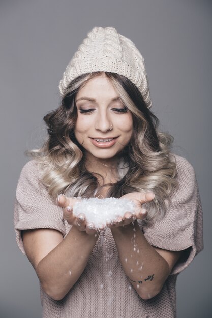 Foto gratuita hermoso retrato de joven mujer atractiva en ropa de punto sobre fondo nevado