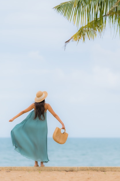 Hermoso retrato jóvenes mujeres asiáticas feliz sonrisa relajarse alrededor de la playa mar océano