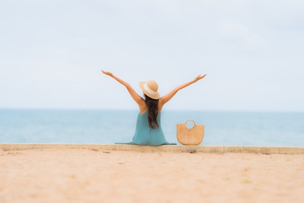 Hermoso retrato jóvenes mujeres asiáticas feliz sonrisa relajarse alrededor de la playa mar océano