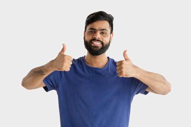 Hermoso retrato de medio cuerpo masculino aislado sobre fondo blanco de estudio. Joven hindú emocional. Expresión facial, emociones humanas, concepto publicitario. Feliz, mostrando el signo de agradable o genial.