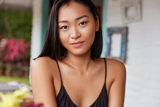 Hermoso retrato de mujer china con peinado bobbed, posa en una acogedora habitación