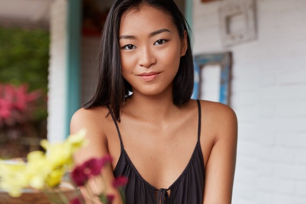 Hermoso retrato de mujer china con peinado bobbed, posa en una acogedora habitación