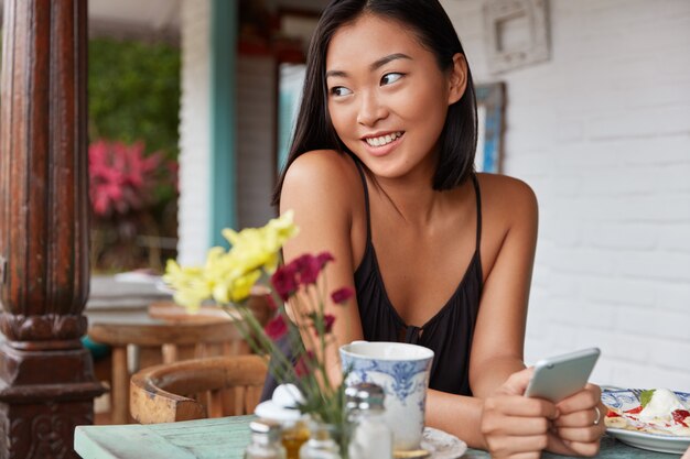 Hermoso retrato de mujer china con peinado bobbed, posa en una acogedora habitación