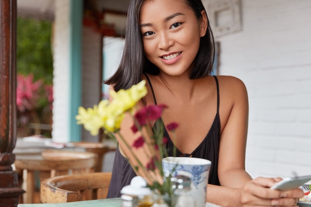 Hermoso retrato de mujer china con peinado bobbed, posa en una acogedora habitación