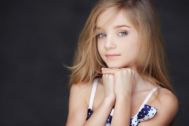 Hermoso retrato de niña con ojos azules. Aislado sobre fondo gris oscuro