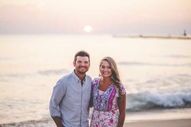 Hermoso retrato de primer plano de una joven pareja posando frente a un impresionante paisaje marino