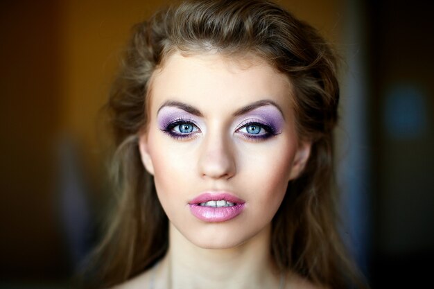 Hermoso rostro femenino joven con estilo de vida de maquillaje multicolor de moda brillante. Ojos azules grandes
