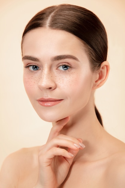 Un hermoso rostro femenino. Piel perfecta y limpia de mujer caucásica joven sobre fondo de estudio pastel.