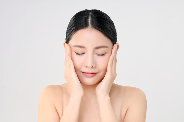 Hermoso rostro de mujer asiática adulta joven con piel limpia y fresca aislada en blanco