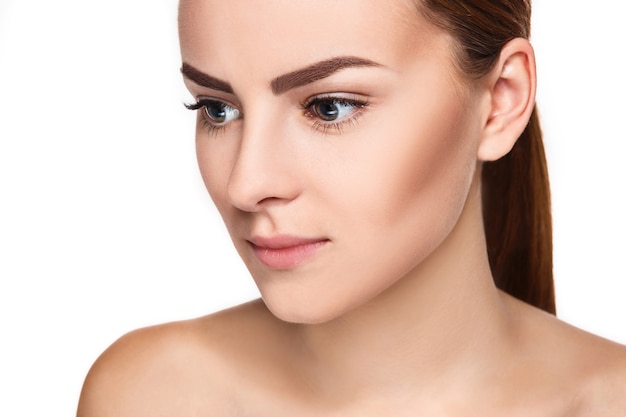 Hermoso rostro de mujer joven con piel limpia y fresca de cerca aislado en blanco. Retrato de belleza. Piel fresca perfecta. Modelo de pura belleza. Concepto de juventud y cuidado de la piel