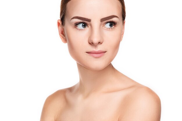 Hermoso rostro de mujer joven con piel limpia y fresca de cerca aislado en blanco. Retrato de belleza. Piel fresca perfecta. Modelo de pura belleza. Concepto de juventud y cuidado de la piel