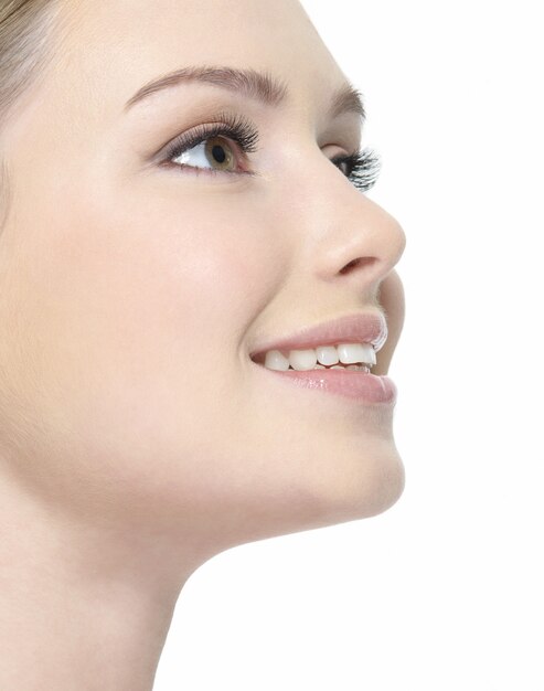 Hermoso rostro sonriente de primer plano de mujer de perfil en blanco