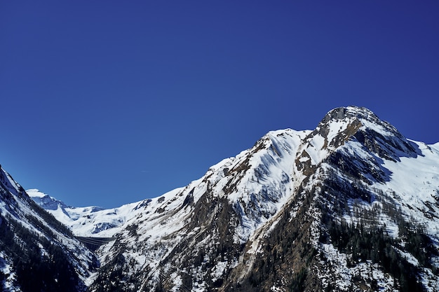 Hermoso tiro de ángulo bajo de una montaña con nieve que cubre el pico y el cielo en el fondo