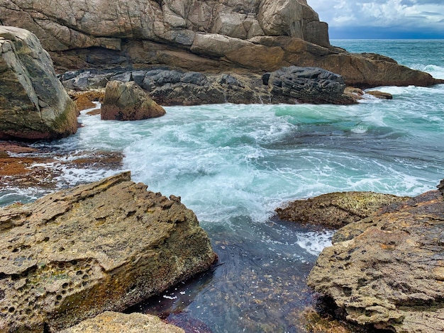 Hermoso tiro de formaciones rocosas cerca del mar con locas olas del mar chocando