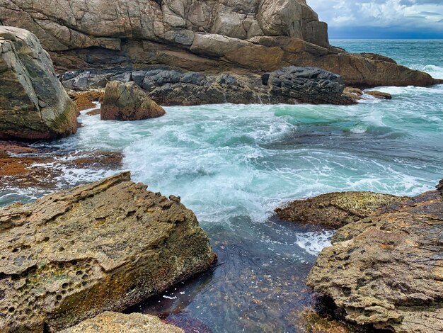 Hermoso tiro de formaciones rocosas cerca del mar con locas olas del mar chocando