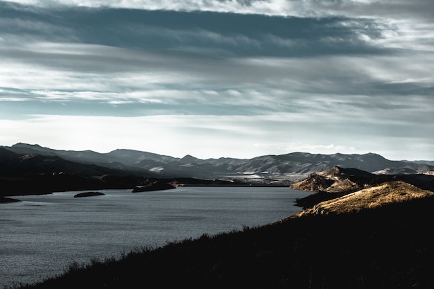 Hermoso tiro de montañas en la orilla del lago durante el amanecer