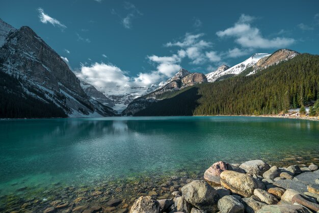 Hermoso tiro de montañas que se refleja en el lago frío bajo el cielo nublado