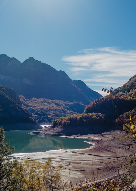 Hermoso tiro de un río en las montañas rodeado de vegetación y un cielo increíble