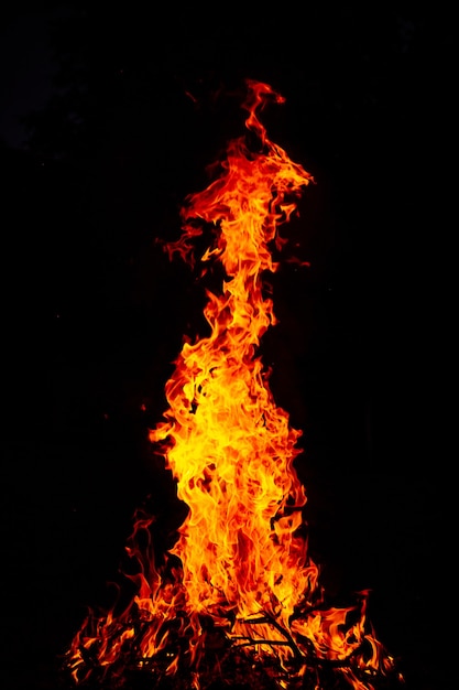 Hermoso tiro vertical de un gran fuego ardiente en la noche