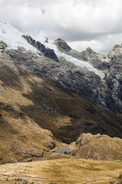 Hermoso tiro vertical de los valles y la nieve en las montañas del Huascarán en Perú