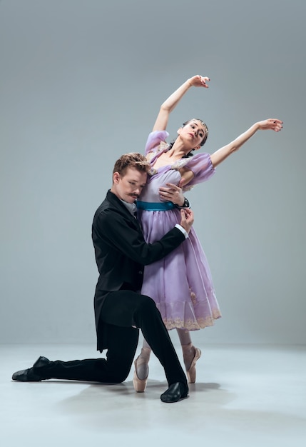 Hermosos bailarines de salón contemporáneos aislados en la pared gris del estudio