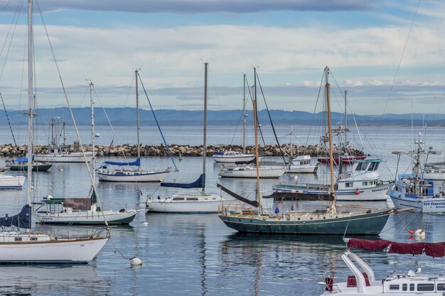 Hermosos barcos de vela en el agua cerca del antiguo muelle de pescadores capturados en Monterey, CA, EE.