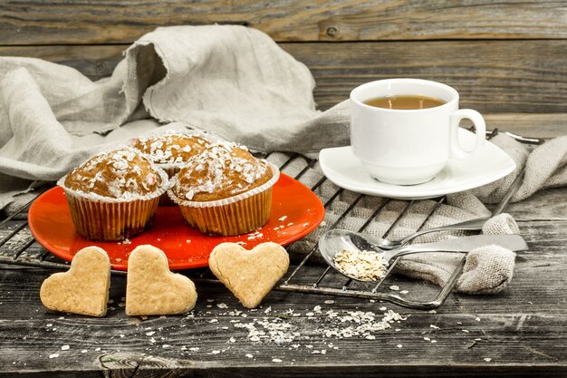 hermosos cupcakes con frutas del bosque sobre fondo de madera en placa roja