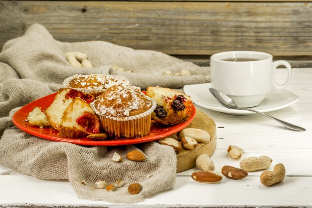 hermosos cupcakes con frutas del bosque sobre fondo de madera en placa roja