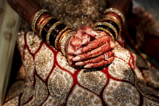 Hermosos diseños de mehndi cubren los dedos de la novia que sostiene