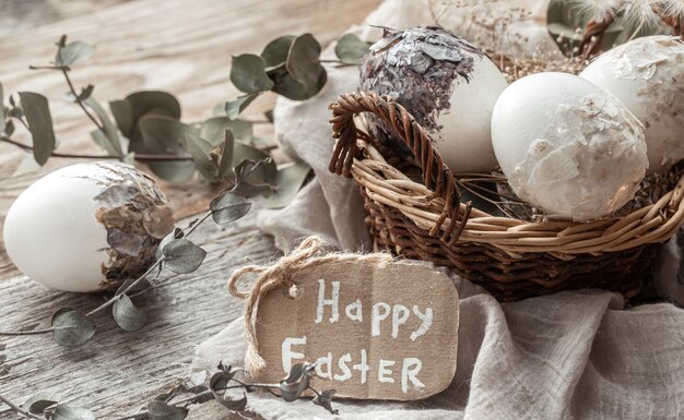 Hermosos huevos de Pascua en una canasta decorada con flores secas. Concepto de Pascua feliz.