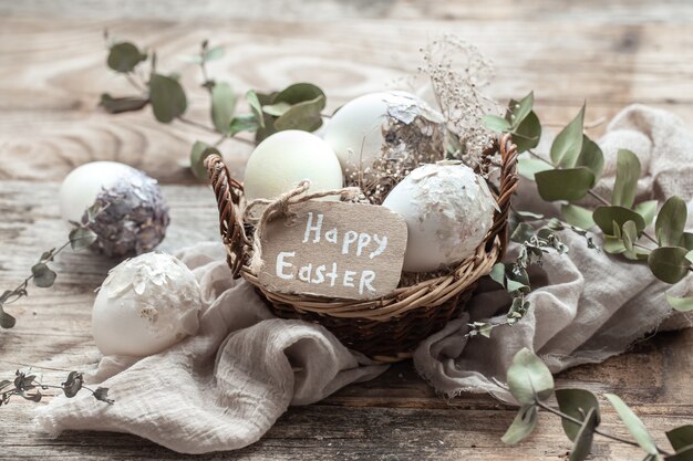 Hermosos huevos de Pascua en una canasta decorada con flores secas. Concepto de Pascua feliz.