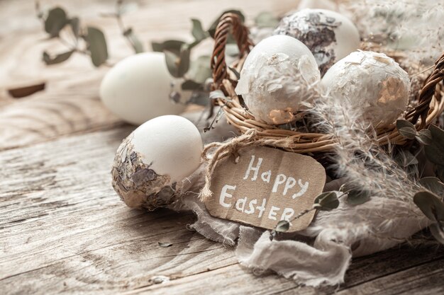 Hermosos huevos de Pascua en una canasta decorada con flores secas. Concepto de Pascua feliz.