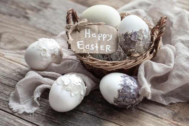 Hermosos huevos de Pascua en una canasta decorada con flores secas. Concepto de Pascua feliz.