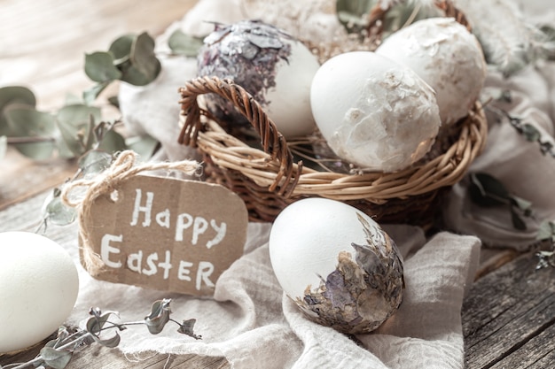 Hermosos huevos de Pascua en una canasta decorada con flores secas. Concepto de Pascua feliz.