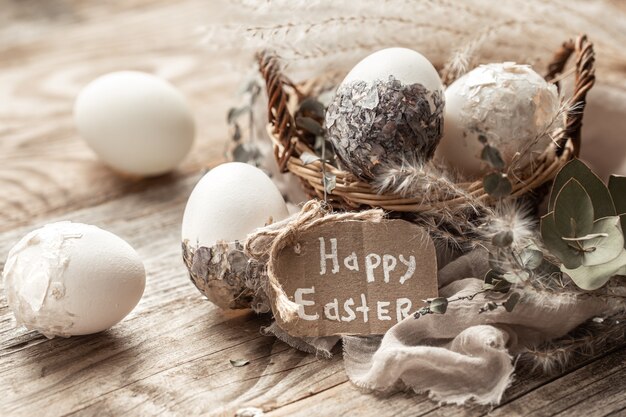 Hermosos huevos de Pascua en una canasta decorada con flores secas. Concepto de Pascua feliz.