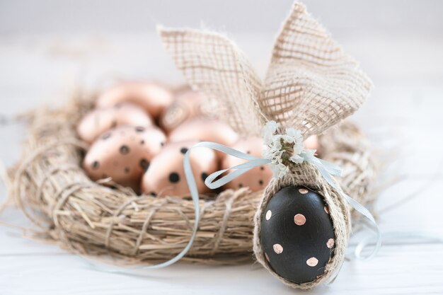 Hermosos huevos de Pascua decorados de color dorado con puntos negros y un huevo negro con puntos dorados