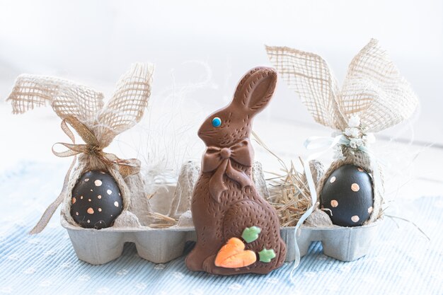 Hermosos huevos de Pascua decorados con conejito de chocolate.