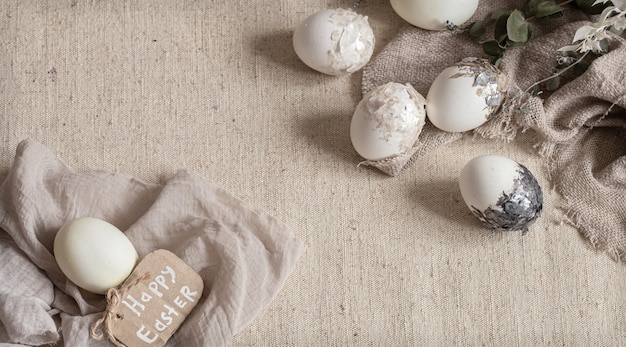 Hermosos huevos de Pascua esparcidos sobre la tela con textura. Concepto de decoración de Pascua.